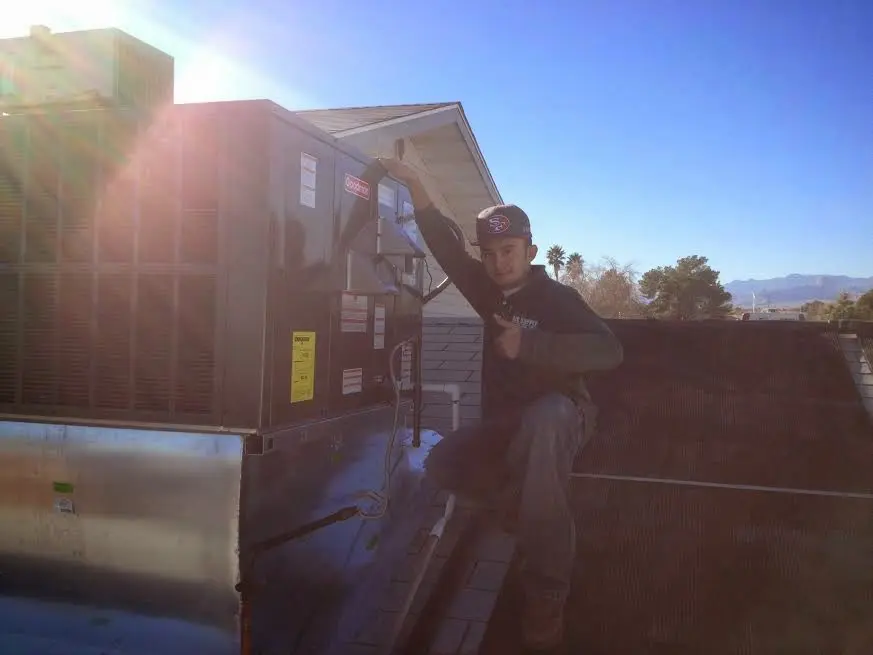 HVAC technician performing Heat Pump Repair on a rooftop unit in Wilmore